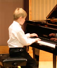 Will Anderson playing grand piano at recital