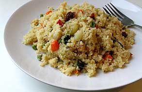 Couscous cooked with vegetables on white plate