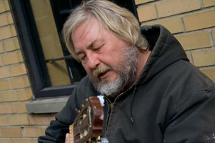 a man strumming his guitar to the blues