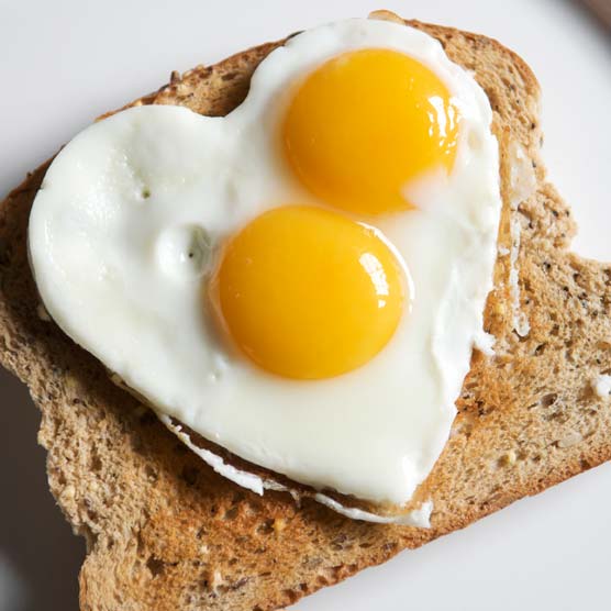 two eggs cooked in a heart shape on toast