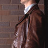 young man standing in front of brick wall