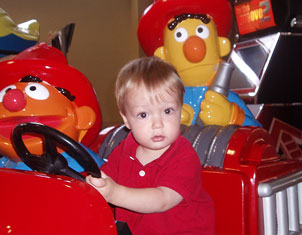 Wyatt Crouch driving a toy fire truck