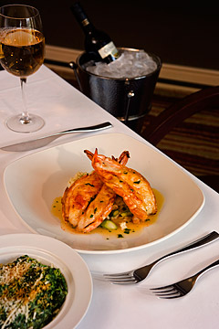 Photo of shrimp scampi and glass of wine on table.