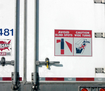 Photo of a text and line drawings, on the back of a truck.