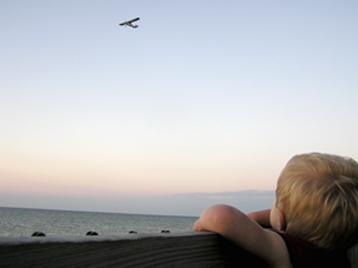 Isaak looking at plane flying over water