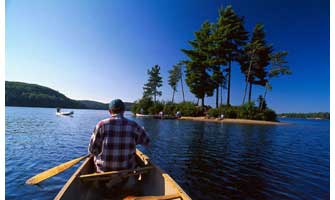 canoe approaches island at Algonquin Park