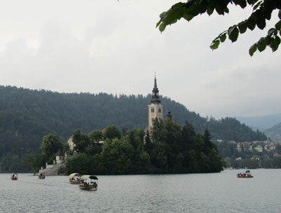 Boats rowing to visit the Pilgrimage Church of the Assumption of Mary, Lake Bled.