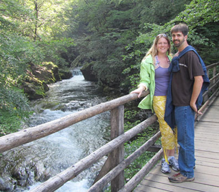 Andrew and Barb standing on a bridge overlooking a waterfall