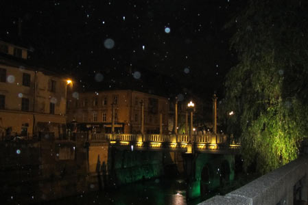 The rain is pouring down as we walk along the river.