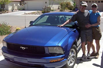 Al and Joanne next to bright blue Ford Mustang