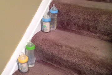 four baby bottles on steps