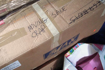 Cardboard box with hand-lettered label saying Yard Sale Crap