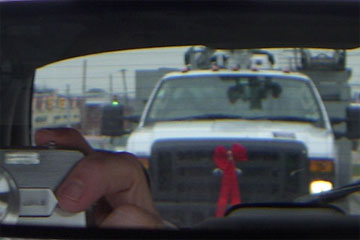 Truck in rear-view mirror with red bow on grill