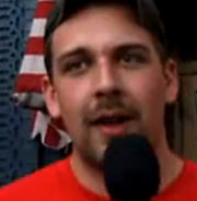 Man in front of American flag, talking