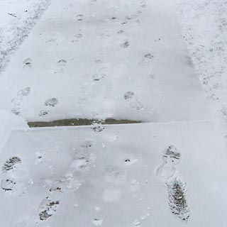Footprints on a snowy sidewalk