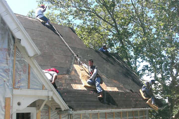 Men working on roof with safety harnesses