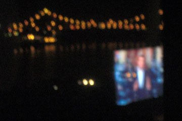 Night view of bridge with reflection of tv in window